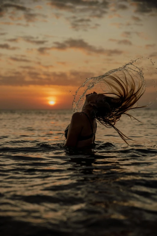 a woman standing in the water with her hair blowing in the wind, unsplash contest winner, sunset lighting 8k, swimming to surface, low detailed, ((sunset))