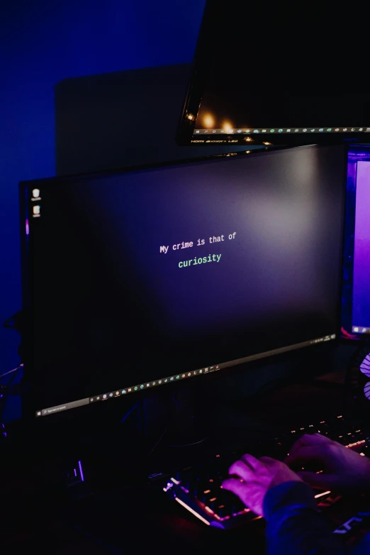 a man sitting in front of a computer monitor, unsplash, computer art, purple glowing inscription, computer setup, lut, discord profile picture