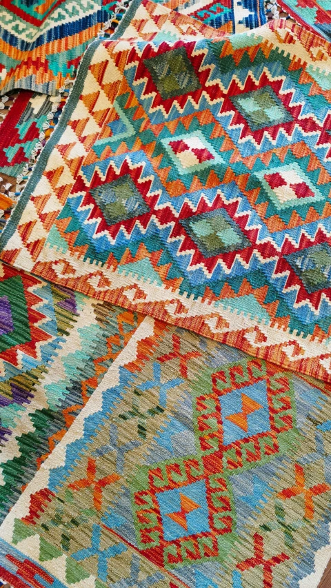 a colorful rug sitting on top of a wooden floor, by Jan Cox, trending on pexels, turquoise and orange, detail shots, arab inspired, zig zag