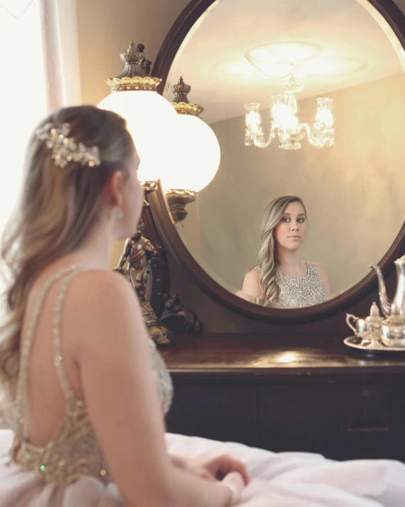 a woman sitting on a bed in front of a mirror, glittery wedding, wearing a formal dress, set photo