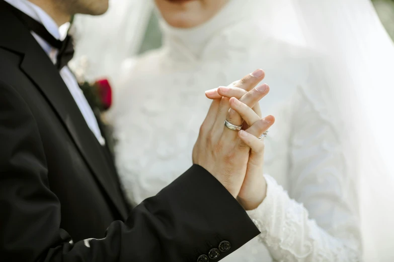 a close up of a bride and groom holding hands, by Anna Findlay, pexels, doing an elegant pose, orthodox, thumbnail, islamic