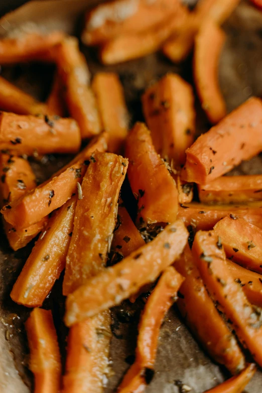 a pan filled with cooked carrots on top of a table, by Carey Morris, pexels, crisps, bottom body close up, hut, thumbnail