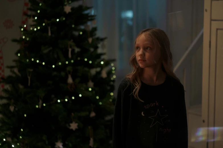 a girl standing in front of a christmas tree, pexels, realism, movie still 8 k, goodnight, tiny girl looking on, production still