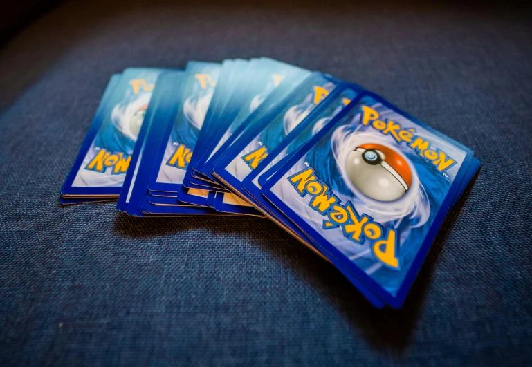 a pile of pokemon cards sitting on top of a couch, by Adam Pijnacker, pexels, pair of keycards on table, swoosh, high quality image, 6 pack