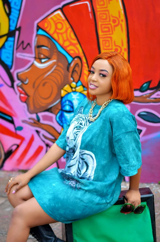 a woman sitting on a suitcase in front of a graffiti wall, an album cover, by Chinwe Chukwuogo-Roy, graffiti, bright orange hair, with teal clothes, doja cat, trending on artisation