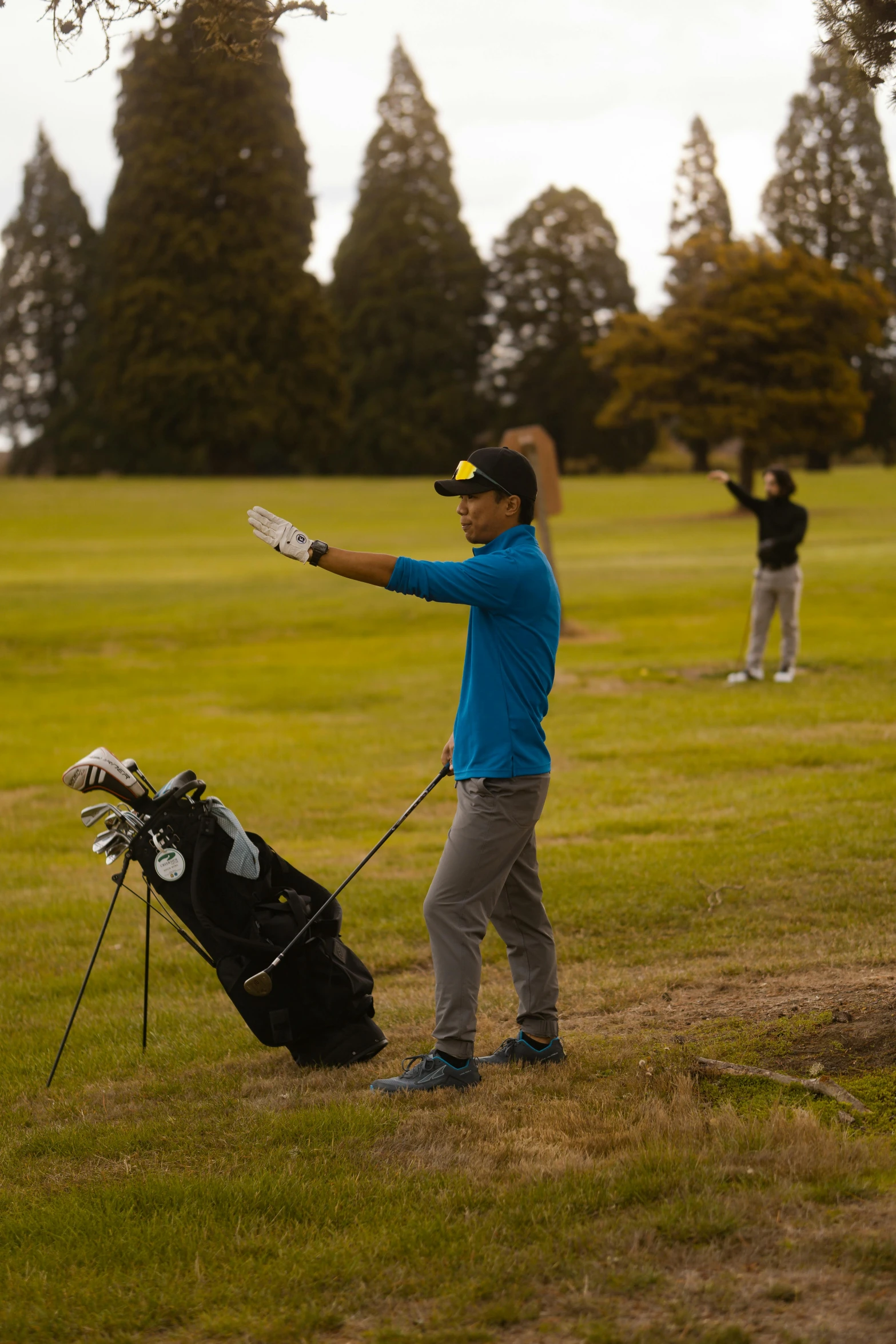 a man holding a golf club on top of a lush green field, high school, ash thorp khyzyl saleem, in an action pose, staff