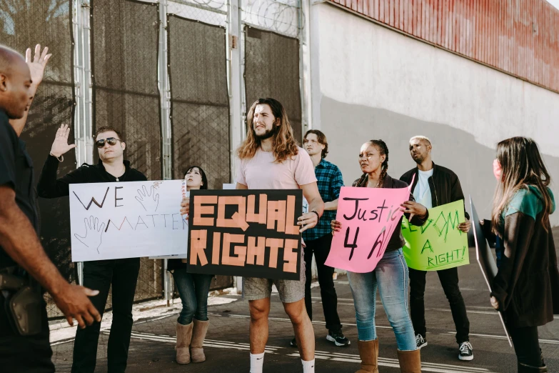 a group of people holding signs in a parking lot, an album cover, by Julia Pishtar, pexels, gay rights, los angeles ca, background image, profile picture 1024px
