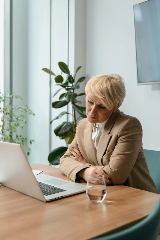 a woman sitting at a table in front of a laptop computer, someone lost job, white haired lady, thumbnail, upset