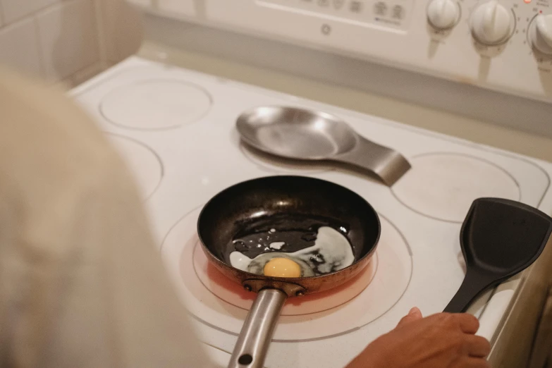 a person cooking food in a frying pan on a stove, an egg, profile image, tiffany dover, dessert