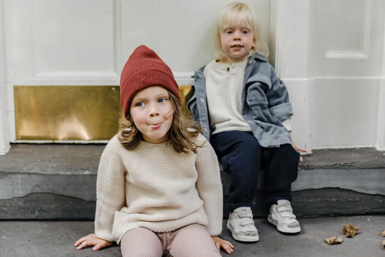 two young children sitting on the steps of a house, by Nina Hamnett, pexels contest winner, sweater, maroon hat, helsinki, sirius a and sirius b
