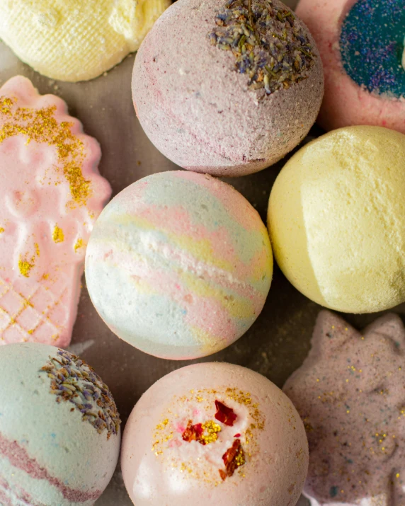 a bunch of bath bombs sitting on top of a table, by Helen Stevenson, shot from above, rainbow, vanilla, pastry