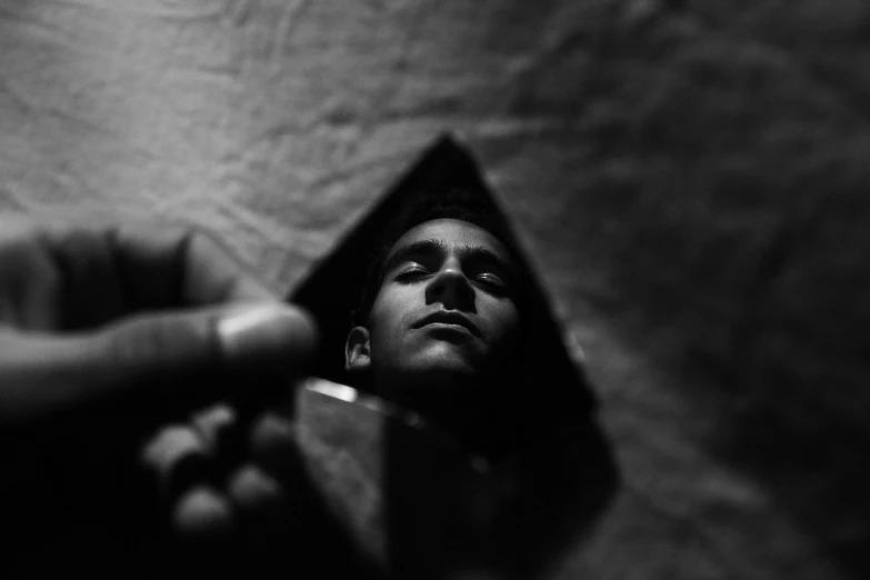 a black and white photo of a man brushing his teeth, a black and white photo, by Adam Chmielowski, unsplash, surrealism, pyramid portal, black teenage boy, lying on an abstract, miniature photography
