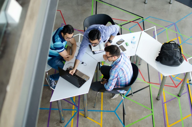 a group of people sitting around a table with laptops, by Adam Marczyński, pexels contest winner, arbeitsrat für kunst, felipe pantone, high angle, standing straight, engineer