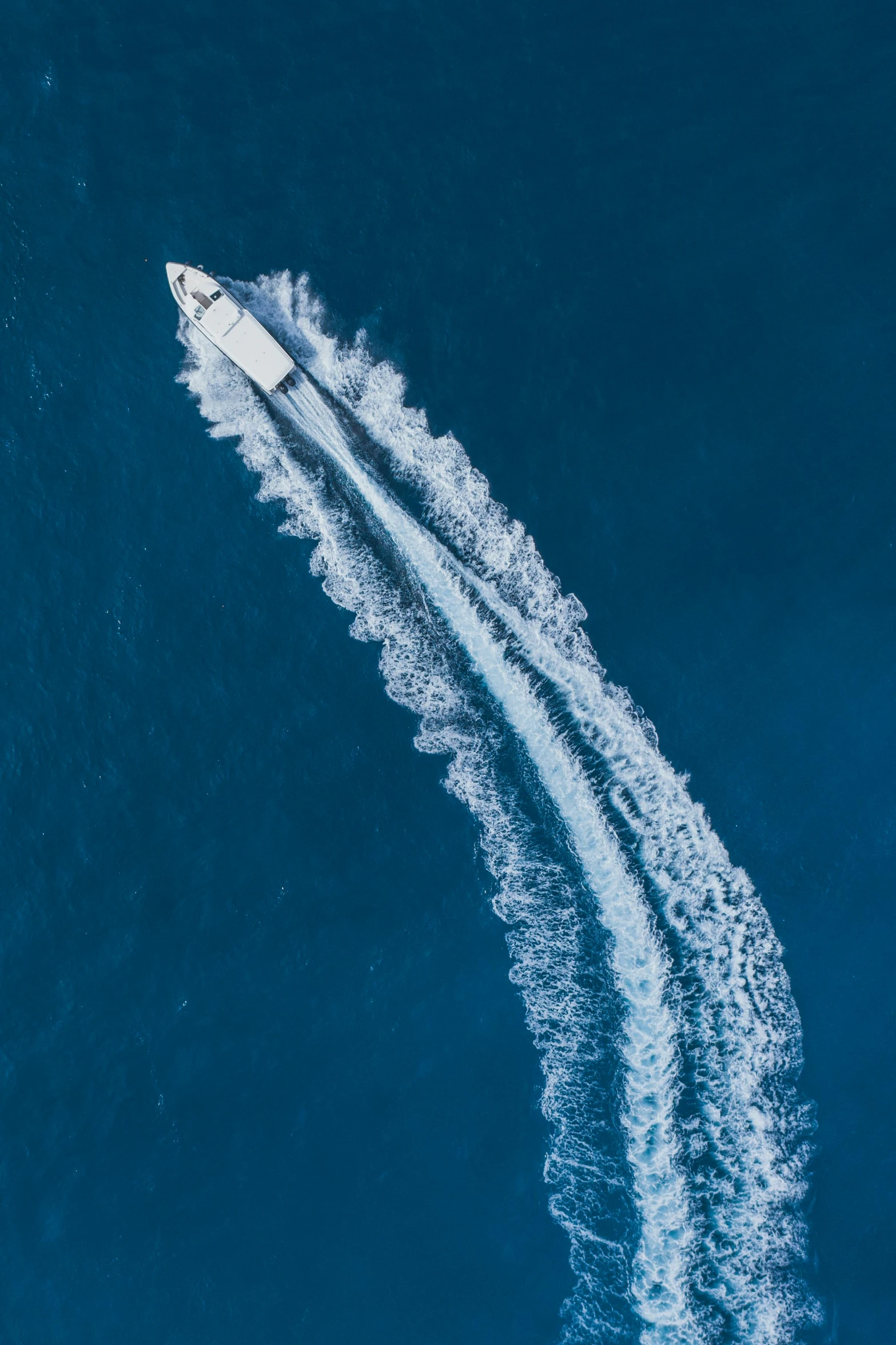 a boat in the middle of a body of water, top down, offshore winds, profile image, tubing