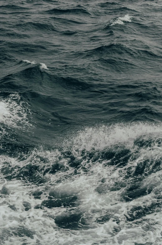 a man riding a surfboard on top of a wave in the ocean, dark ocean water, still photograph, ignant, turbulence