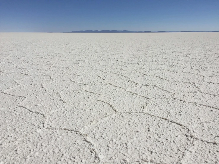 a vast expanse of salt with mountains in the distance, photo taken in 2018, flat, looking left, very sparse detail