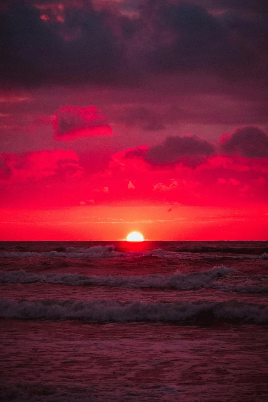 the sun is setting over the ocean on a cloudy day, by Andries Stock, color red, magenta, 2019 trending photo, reds