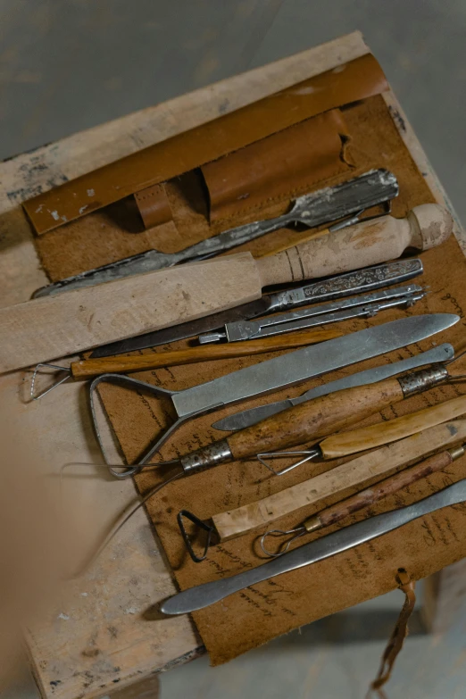 a bunch of tools sitting on top of a wooden table, arte povera, surgical implements, paul barson, carefully crafted, scrathes