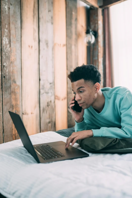 a man laying on a bed using a laptop computer, trending on pexels, renaissance, black teenage boy, have a call to action, looking distracted, full-body