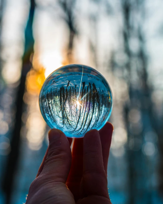 a person holding a crystal ball in their hand, by Robert Richenburg, unsplash contest winner, sunny winter day, glass and lights, inside a marble, 5 0 0 px