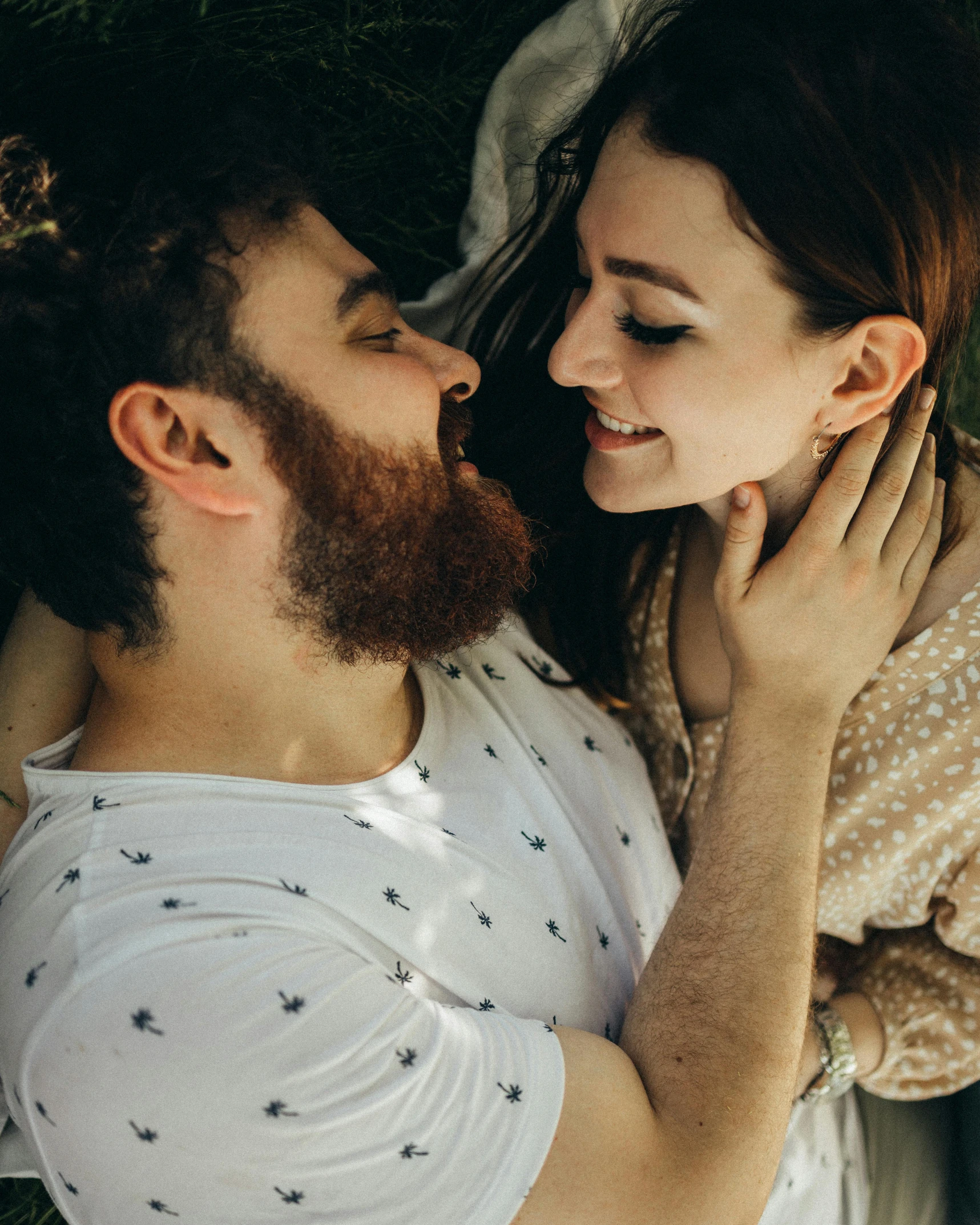 a man and a woman laying in the grass, trending on unsplash, renaissance, bushy beard, lesbian embrace, looking straight, wholesome