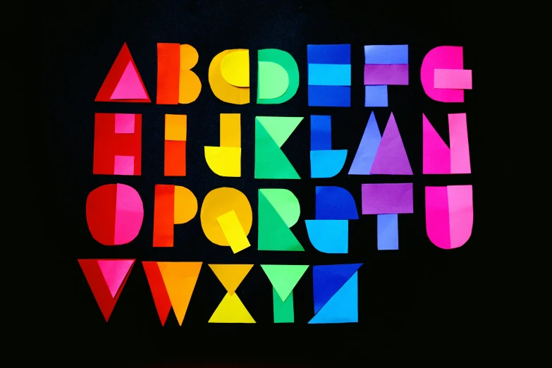 a multicolored alphabet on a black background, an album cover, inspired by Stanton Macdonald-Wright, unsplash, paper craft, public art, mid morning lighting, teacher