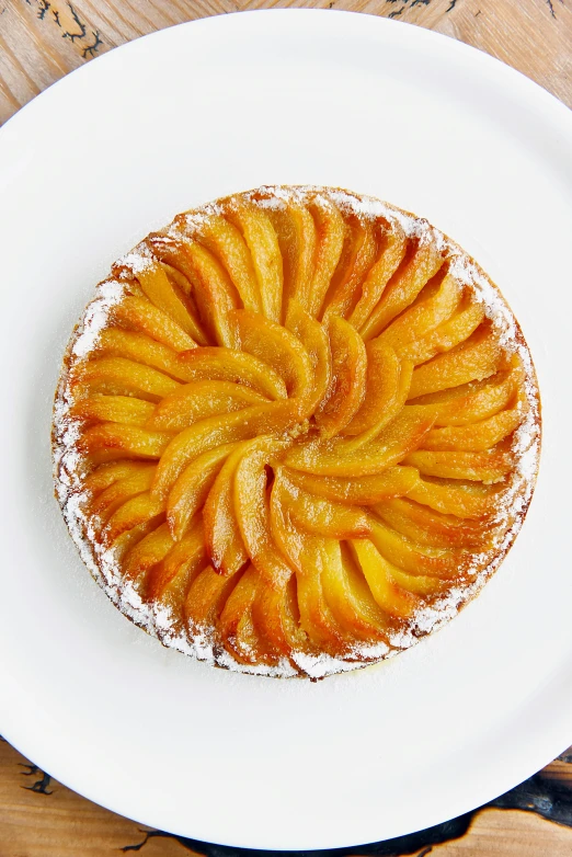 a white plate topped with a pastry on top of a wooden table, inspired by Charles Le Roux, renaissance, peaches, 1x, large crown, various sizes