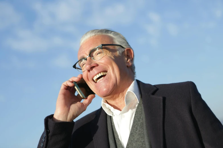 a man with glasses talking on a cell phone, inspired by John Murdoch, pexels contest winner, white hair floating in air, selling insurance, sunny sky, 15081959 21121991 01012000 4k