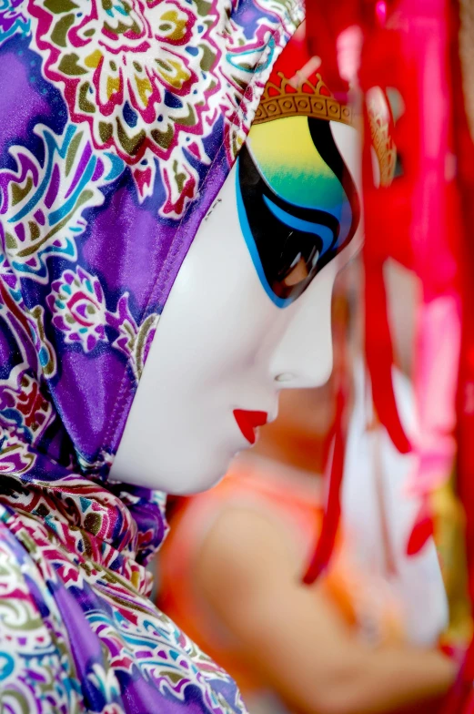 a close up of a mannequin wearing a colorful headdress, an album cover, inspired by Hirohiko Araki, trending on pexels, cloisonnism, venetian mask, orientalisme, oriental scene, pretty face sharp chine