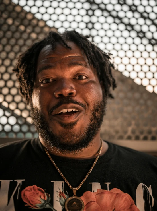 a man with dreadlocks standing in front of a building, lizzo, close-up photograph, he is wearing a black t-shirt, thumbnail