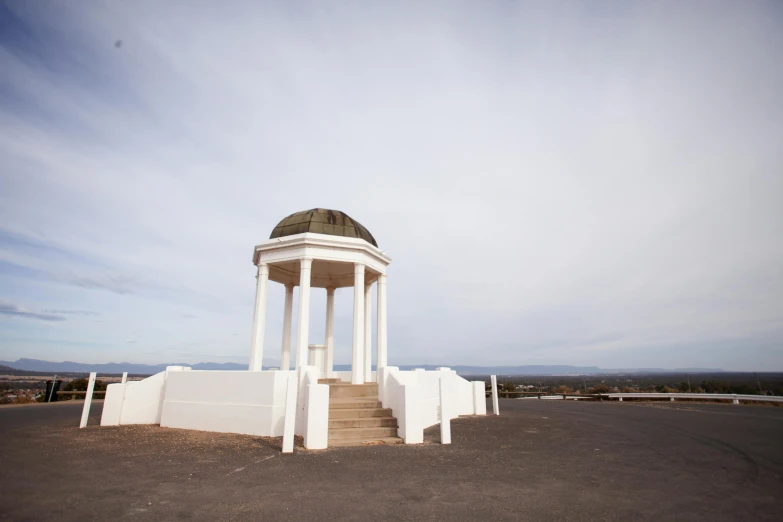 a white gazebo sitting on top of a parking lot, by Lee Loughridge, unsplash, baroque, hillside desert pavilion, seaview, monument, white sky