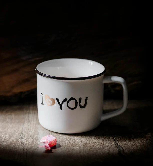a white cup sitting on top of a wooden table, i love you, enamel, product image, brown