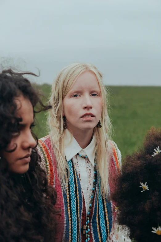 a group of women standing next to each other in a field, an album cover, by Anna Boch, trending on pexels, aztec hair, inuit, portrait of two people, goldilocks