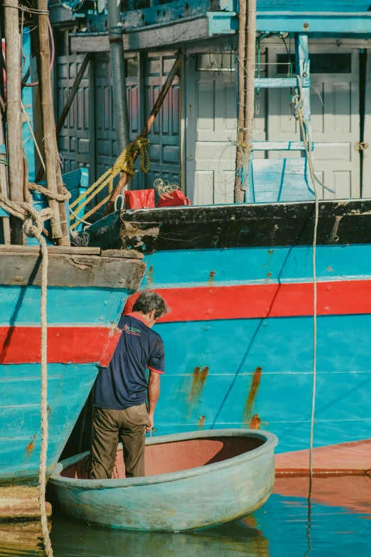 a man in a boat on a body of water, a colorized photo, inspired by Steve McCurry, pexels contest winner, docked at harbor, brown and cyan blue color scheme, inspect in inventory image, vietnam