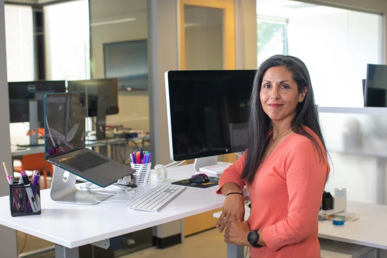 a woman standing in front of a computer desk, henry ascensio, multi - level, cupertino, sam nassour