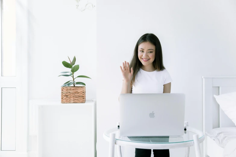 a woman sitting in front of a laptop computer, inspired by helen huang, pexels contest winner, waving, white room, standing confidently, avatar image