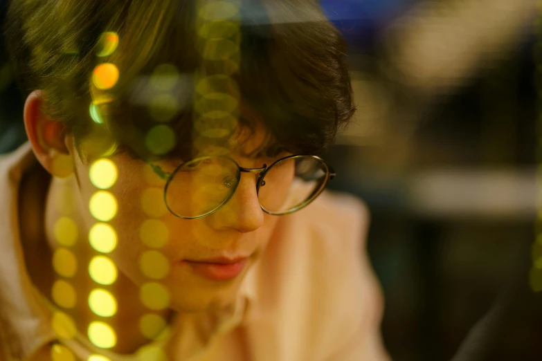 a close up of a person looking at a cell phone, inspired by Kim Eung-hwan, pexels contest winner, yellow lights, man with glasses, profile shot, stillframe