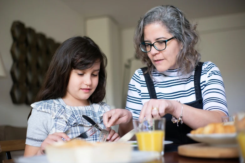 a woman and a little girl sitting at a table, pexels, silver egg cup, holding a kitchen knife, wearing medium - sized glasses, avatar image