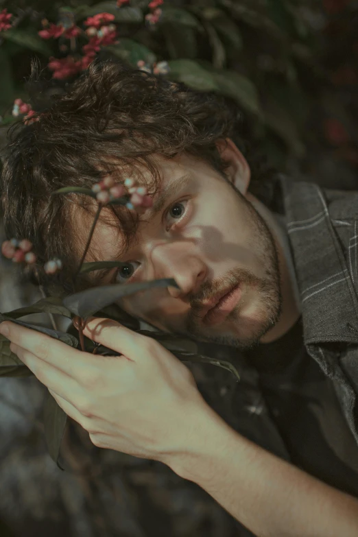 a man holding a rifle in front of a bush, an album cover, inspired by miles johnston, pexels contest winner, photorealism, young handsome pale roma, headshot profile picture, will graham, covered in leaves