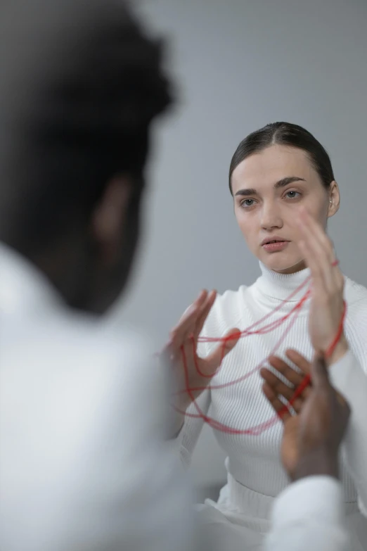 a woman that is standing in front of a mirror, inspired by Anna Füssli, interactive art, with a stethoscope, focused on her neck, hand gestures, florence pugh