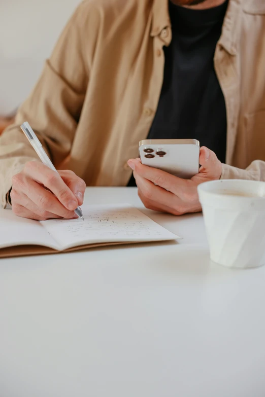 a person sitting at a table with a cup of coffee and a cell phone, a drawing, trending on pexels, diary on her hand, no - text no - logo, plain background, intricate writing