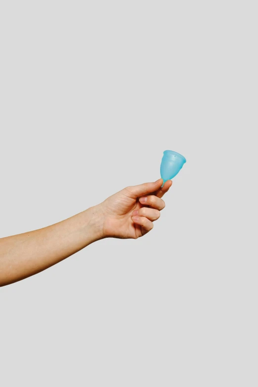 a person holding a blue cup in their hand, gum tissue, prototype, cone shaped, silicone skin