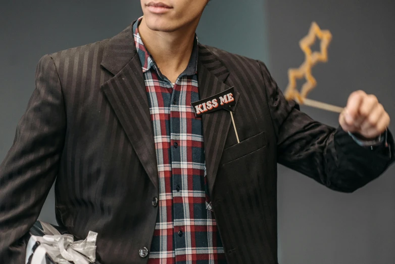 a man holding a stick with a star on it, kinetic art, wearing a blazer, wearing a plaid shirt, costume design made with love, medium close up