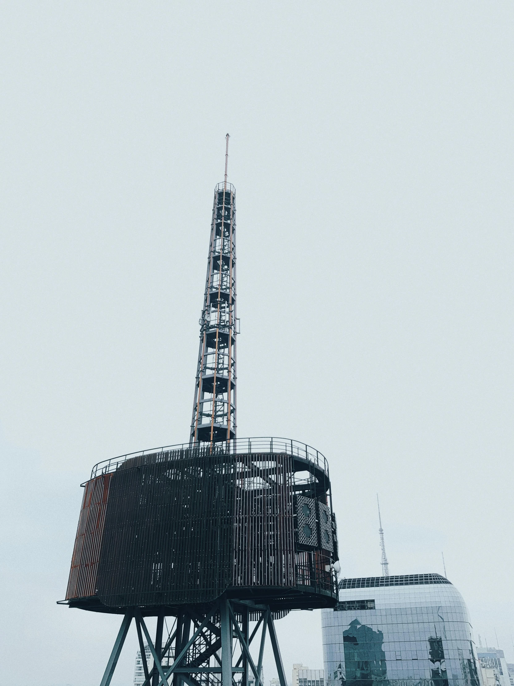 a tall tower sitting on top of a body of water, an album cover, unsplash, brutalism, neo norilsk, foggy photo 8 k, lone industrial!!! spaceship!!, vsco
