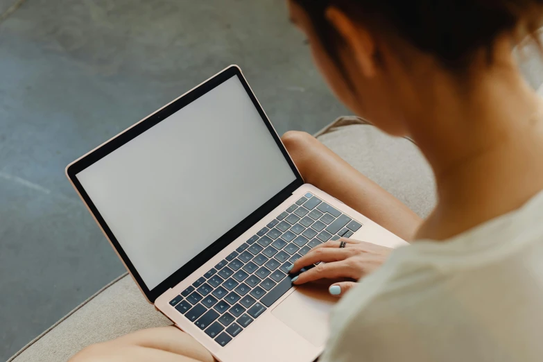 a woman sitting on a couch using a laptop computer, by Carey Morris, trending on pexels, rectangle, rounded lines, sitting on the ground, glossy surface