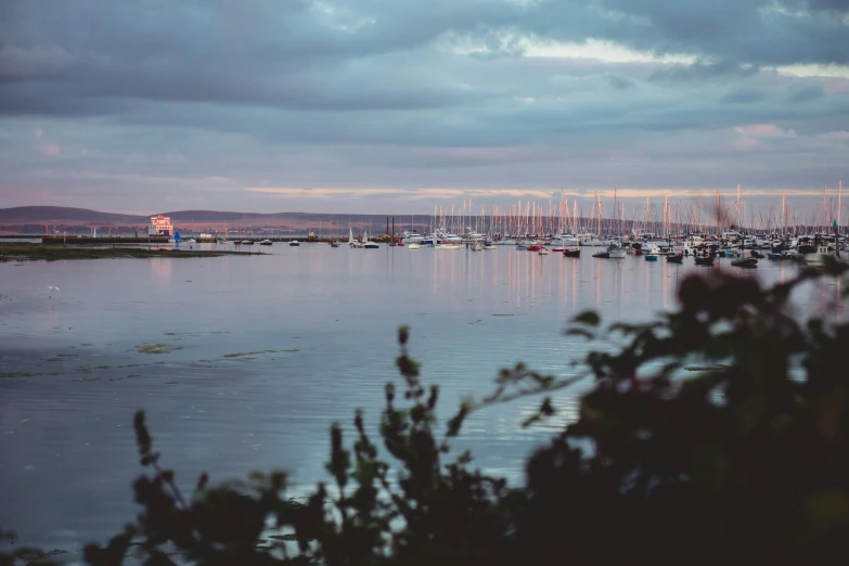 a harbor filled with lots of boats under a cloudy sky, by Rachel Reckitt, pexels contest winner, late summer evening, faded glow, holywood scene, ignant