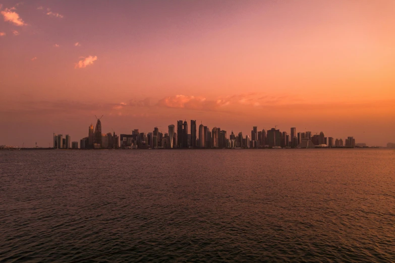 a large body of water with a city in the background, by Daniel Lieske, pexels contest winner, hurufiyya, pink golden hour, gulf, panoramic, middle east