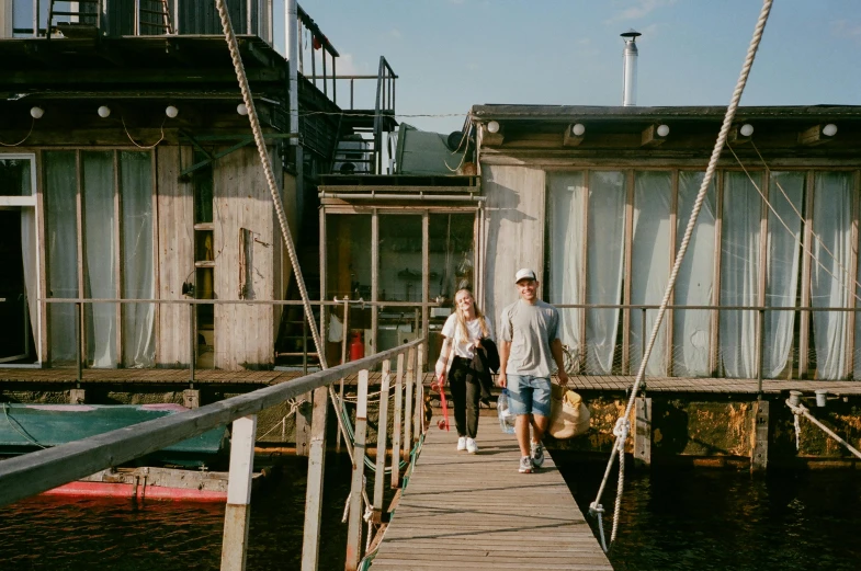 a man and a woman walking across a pier, airbnb, vessels, jovana rikalo, at the waterside