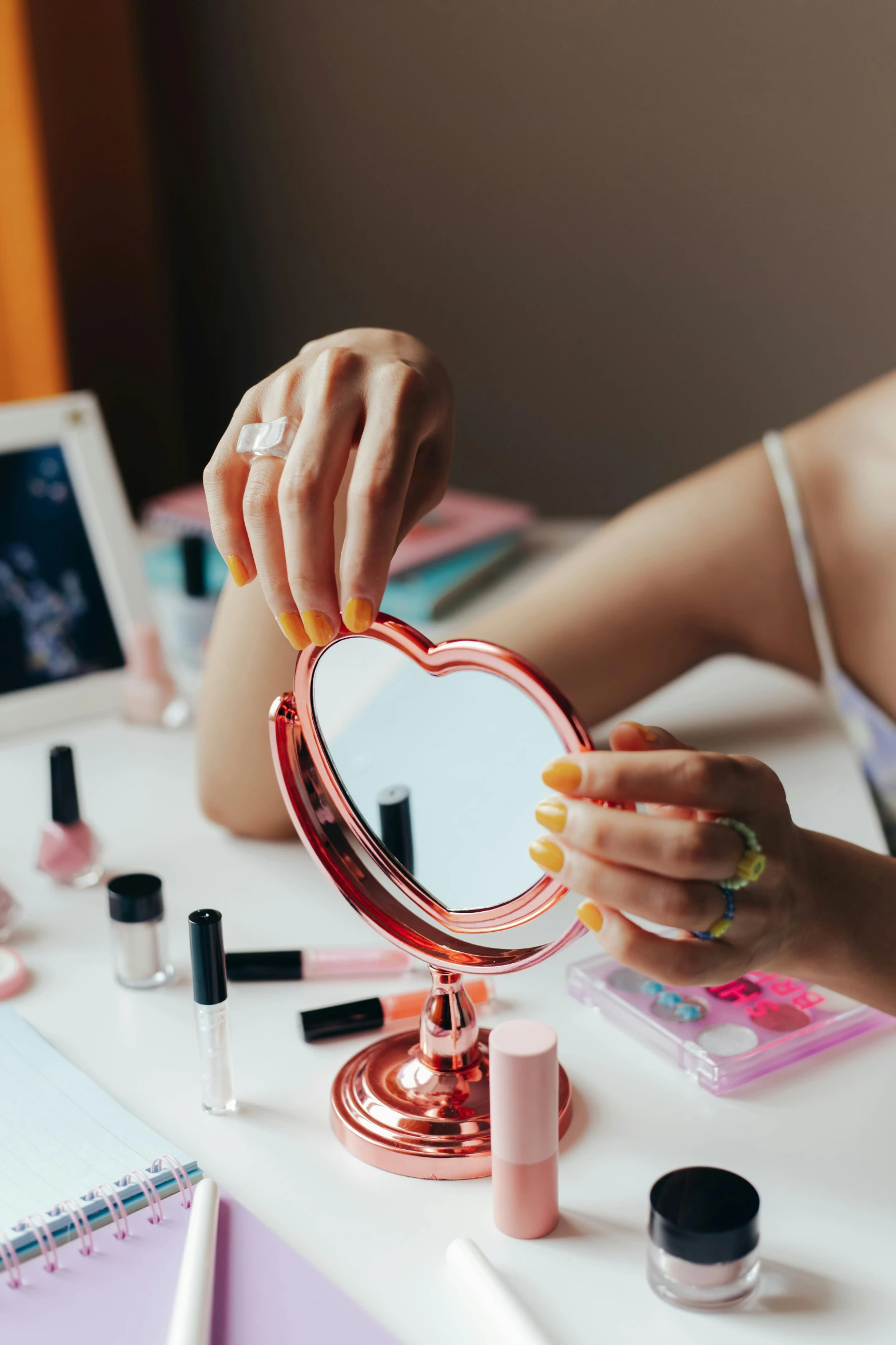 a woman is doing makeup in front of a mirror, a colorized photo, trending on pexels, aestheticism, back of hand on the table, pink and red color scheme, holding up a night lamp, flat lay