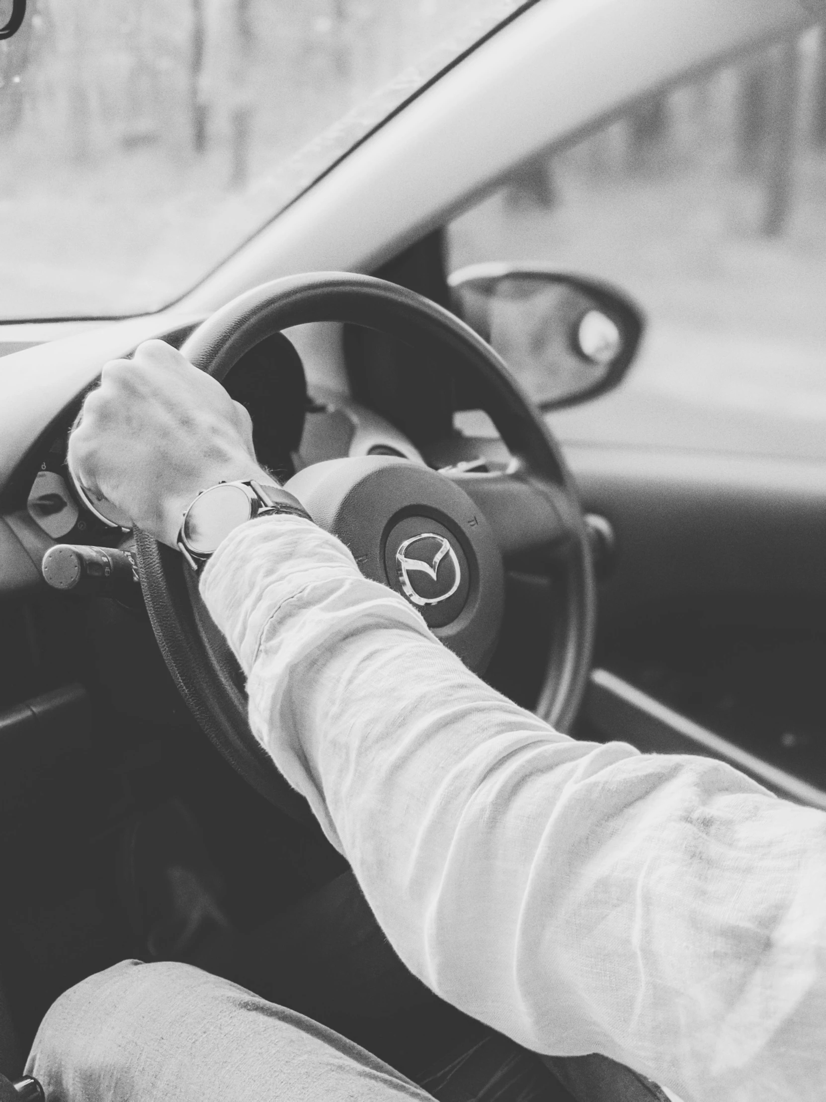 a black and white photo of a man driving a car, by Adam Marczyński, pexels, bandage on arms, white jacket, circle, promo image